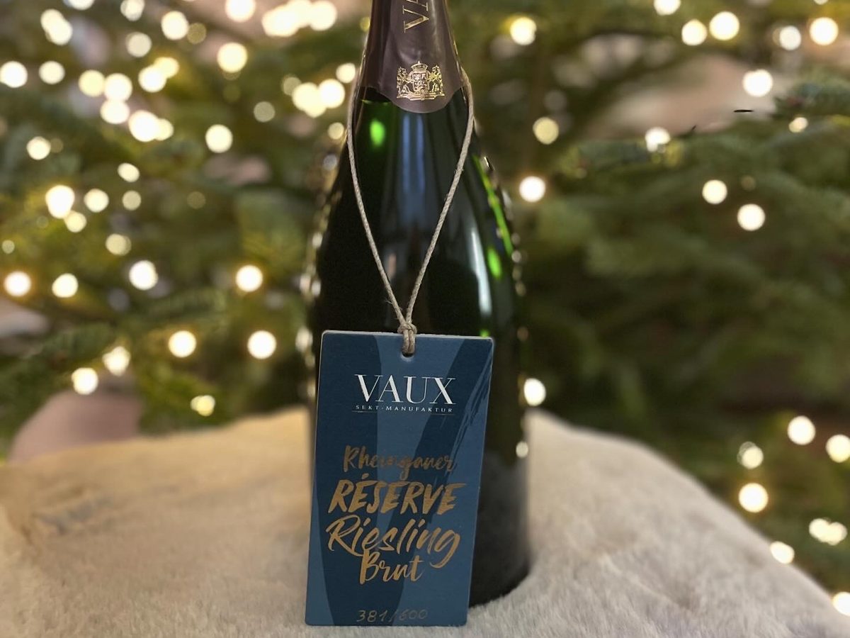 Sektflasche vor dem geschmückten Weihnachtsbaum