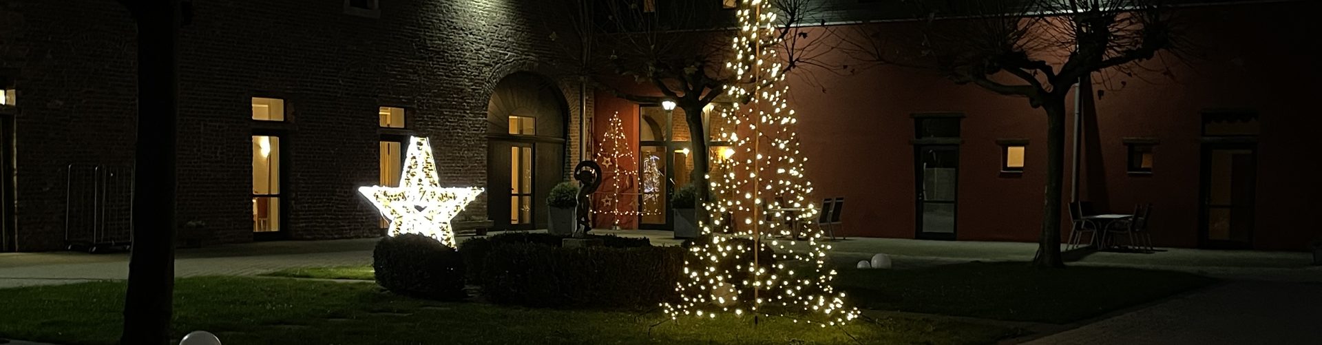 Innenhof von Burg Obbendorf am Abend mit Leuchtstern und Lichterbaum